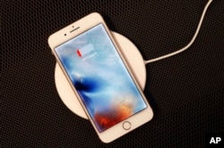 In this Sept. 15, 2017, photo, the iPhone 8 Plus rests on a wireless charger in New York.