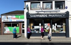 Warga mengenakan masker saat berjalan di kawasan Mountain Ash, Inggris, di tengah pandemi Covid-19, 18 September 2020.