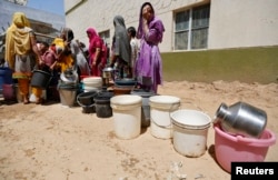 Residents wait for their turn to fill their containers with water, next to a municipal corporation water tanker in Maktampura neighborhood in Ahmedabad, April 7, 2016.
