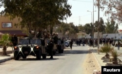Security forces keep watch during a protest in the southern Tunisian town of Dhiba, near the border with Libya, Feb. 9, 2015.