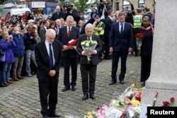 Britain's Prime Minister David Cameron, second from right, stands with Labour Party leader Jeremy Corbyn, left, John Bercow, Speaker of the House of Commons, center, and Labour MP Hilary Benn, second left, as they pay tribute near the scene where Labour Member of Parliament Jo Cox was killed in Birstall, near Leeds, June 17, 2016.