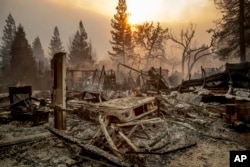 A vintage car rests among debris as the Camp Fire tears through Paradise, Calif., on Nov. 8, 2018.