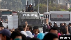 Protesters gesture with four fingers after blocking Al Nasr street in front of Al-Azhar University headquarters at Cairo's Nasr City district, Nov. 19, 2013.