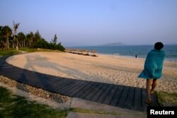중국 하이난성 산야시에서 여성이 해변을 향해 걸어가고 있다.