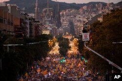 Backdropped by the Sagrada Familia church, demonstrators march during a protest calling for the release of Catalan jailed politicians, in Barcelona, Spain, Nov 11, 2017.