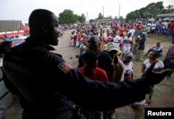 People wait to vote during the presidential election at a polling station of Duport Road in Monrovia, Liberia, Oct. 10, 2017.