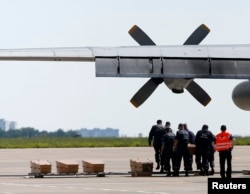 Coffins containing remains of some of the victims of Malaysia Airlines MH17 are placed on the tarmac before being loaded onto a transport plane heading toward the Netherlands, at the airport in Kharkiv, Ukraine, July 23, 2014.