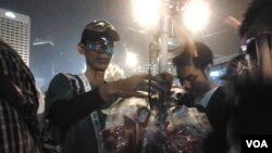 Seorang pedagang berjualan topeng di malam pergantian tahun 2012-2013 di seputar bundaran Hotel Indonesia, Jakarta (VOA/Iris Gera)