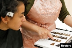 A woman picks out a color to get highlights in her hair at the Le'Jemalik Salon and Boutique ahead of the Eid al-Fitr Islamic holiday in Brooklyn, New York, June 21, 2017.