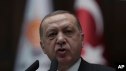 Turkey's President and leader of ruling Justice and Development Party Recep Tayyip Erdogan addresses the members of his ruling party at the parliament in Ankara, Turkey, Tuesday, Feb. 13, 2018.