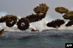 FILE - South Korean Marine amphibious assault vehicles fire smoke shells to land on the seashore during a joint landing operation by US and South Korean Marines in the southeastern port of Pohang, March 30, 2015.