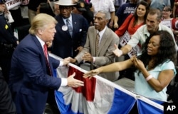 FILE - Republican presidential hopeful Donald Trump shakes hands with supporters after speaking at a campaign event in Dallas, Texas, Sept. 14, 2015.