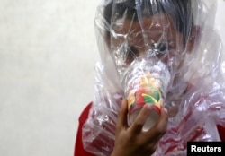 A boy tries on an improvised gas mask in Idlib, Syria, Sept. 3, 2018.