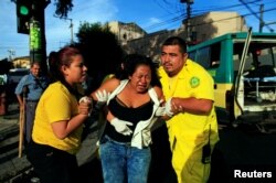 Rescuers Maria Martinez, left, and Renato Landaverde help a woman who was hit by a bus in San Salvador, El Salvador, July 17, 2016.