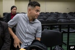 Jose Manuel Morales Marroquin, the son of Guatemala's President Jimmy Morales, center, sits in a courtroom waiting for a hearing in Guatemala City, Aug. 30, 2017.