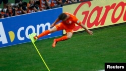 Klaas-Jan Huntelaar of the Netherlands kicks a corner flag to celebrate his goal against Mexico at the Castelao arena in Fortaleza, June 29, 2014.