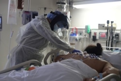 Seorang staf medis merawat pasien Covid-19 di Unit Perawatan Intensif (ICU), Rumah Sakit Rahmat Scripps di Chula Vista, California, AS, 12 Mei 2020. (REUTERS / Lucy Nicholson / File Foto)