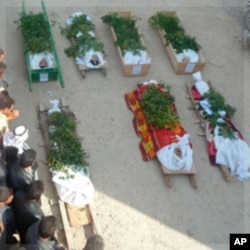 Anti-government protesters pray next to the bodies of people who were among the Sunni Muslims killed, in Hula near Homs, Syria, November 2, 2011.