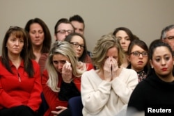 Victims and others look on as Rachael Denhollander speaks at the sentencing hearing for Larry Nassar, a former team USA Gymnastics doctor who pleaded guilty in November 2017 to sexual assault charges, in Lansing, Michigan, Jan. 24, 2018.