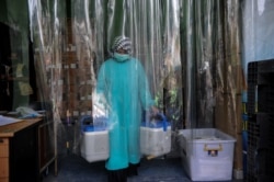 Petugas medis membawa vaksin COVID-19 di Bandung, Jawa Barat, 13 Januari 2021. (Foto: Raisan Al Farisi/Antara via REUTERS)