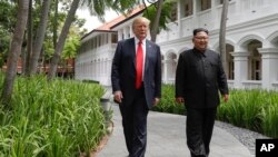 U.S. President Donald Trump and North Korea leader Kim Jong Un walk from their lunch at the Capella resort on Sentosa Island Tuesday, June 12, 2018 in Singapore. (AP Photo/Evan Vucci)