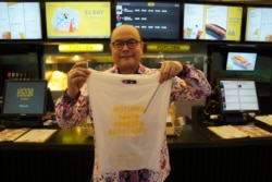 David Hilman memperlihatkan tas plastik dari singkong yang digunakan di Flix Cinema. (Foto: VOA/Henry Irvin)
