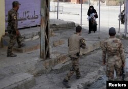 A woman holds her child as she crosses from an Islamic State-controlled part of Mosul into an Iraqi special forces-controlled part of Mosul, Iraq, Nov. 14, 2016.