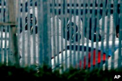 Police officers wear protective suits inside the fence of "Ashley Wood Recovery", a vehicle recovery business in Salisbury, near where the car of Sergei Skripal was taken on March 13, 2018.
