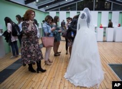 A visitor looks at a wedding dress displayed at the Museum of Broken Relationships in Pristina, Kosovo,May 3, 2018. The dress belongs to a Turkish woman who lost her husband-to-be the day they would get married, June 28, 2016, when a terrorist attack kill