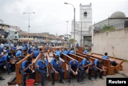 Workers sit on pews as they take a break from repairs outside St. Anthony's Shrine a week after a string of suicide bomb attacks across the island on Easter, in Colombo, Sri Lanka, April 28, 2019.