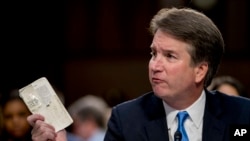 Supreme Court nominee Brett Kavanaugh, a federal appeals court judge, holds up a worn copy of the Constitution of the United States as he testifies before the Senate Judiciary Committee on Capitol Hill in Washington, Sept. 5, 2018.