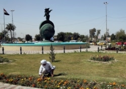 Seorang tukang kebun sedang membersihkan Nisoor Square, lokasi penembakan maut oleh kontraktor keamanan swasta, Blackwater, pada 2007, Baghdad, Irak, 15 April 2015.
