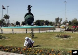 A gardener tends to flowers in Nisoor Square, the site of a deadly shootout by Blackwater private security contractors in 2007, in Baghdad, Iraq, April 15, 2015.