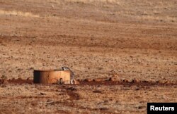 A kangaroo drinks from a water tank located in a drought-affected paddock on farmer Ash Whitney's property, located west of the town of Gunnedah in northwestern New South Wales, Australia, June 3, 2018.