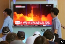 FILE - In this July 29, 2017 photo, People watch a TV news program showing an image of a North Korea test launch of an intercontinental ballistic missile, at the Seoul Railway Station in South Korea.
