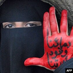 Namoyishchi ayolning qo'lidagi yozuv: "Qonimiz inqilob uchun kuch beradi"