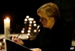 German Chancellor Angela Merkel signs the condolence book at the Memorial Church in Berlin, Germany, Dec. 20, 2016, one day after a truck ran into a crowded Christmas market in Berlin and killed several people.