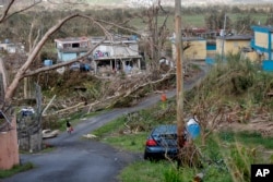 Jonathan Aponte walks with a gas can up the road to his home in the aftermath of Hurricane Maria, in Yabucoa, Puerto Rico, Sept. 26, 2017.