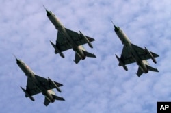 Indian Air Force MIG 21 jet fighters perform during a parade at an airbase in Tezpur, India, Nov. 21 2014.