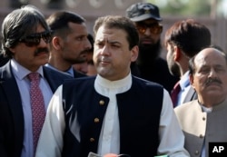 FILE - Hussain Nawaz, center, son of Pakistan's Prime Minister Nawaz Sharif, talks to reporters outside the premises of the Joint Investigation Team, in Islamabad, Pakistan, June 1, 2017, following his appearance before the panel.