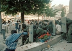 FILE - Riot police are trapped by attacking protesters during clashes in the center of Seoul as opposition groups mounted major demonstrations to demand the fall of the government of President Chun Doo-hwan, June 10, 1987.