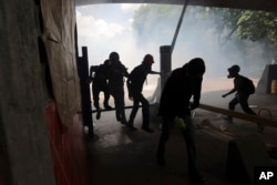 Students run from tear gas fired by National Police outside the Central University of Venezuela in Caracas, May 4, 2017.