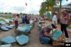 FILE - Gem merchants examine jade at a sale in Yangon, Myanmar, July 3, 2006.