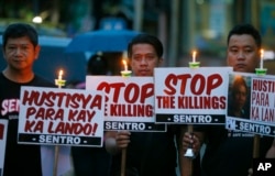Protesters hold placards in a candlelit protest against extrajudicial killings in President Rodrigo Duterte's "War on Drugs" campaign in suburban Quezon city, northeast of Manila, Philippines, Oct. 8, 2016.