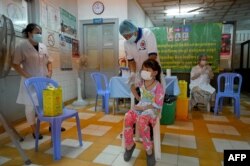 រូបឯកសារ៖ កុមារី​ម្នាក់ ទទួល​ការចាក់​វ៉ាក់សាំង​បង្ការ​ជំងឺ​កូវីដ១៩ Sinovac នៅ​មណ្ឌល​សុខភាព​មួយ​កន្លែង​ក្នុង​រាជធានី​ភ្នំពេញ កាលពី​ថ្ងៃទី១ ខែវិច្ឆិកា ឆ្នាំ២០២១ ខណៈ​កម្ពុជា ចាប់ផ្ដើម​ចាក់​វ៉ាក់សាំង​ដល់​កុមារ​ចាប់ពី​អាយុ៥​ឆ្នាំ​ឡើង​ទៅ។