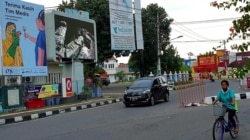 Warga melintas di depan baliho ucapan terima kasih untuk tenaga medis di Yogyakarta. (Foto:VOA/Nurhadi)