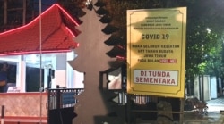 Baliho di depan gerbang masuk Taman Budaya Jawa Timur mengumumkan penundaan semua pentas seni dan budaya selama dua bulan (Foto:VOA/Petrus Riski).