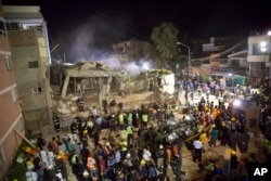Volunteers and rescue workers search for children trapped inside at the collapsed Enrique Rebsamen school in Mexico City, Sept. 19, 2017.
