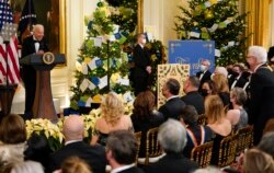 President Joe Biden looks at actor Steve Martin, standing right, a he speaks during the Kennedy Center Honorees Reception at the White House in Washington, Dec. 5, 2021.