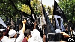 Umat Islam melakukan protes atas pembakaran bendera bertuliskan kalimat tauhid pada aksi di Jakarta, Jumat (26/10). (Foto: VOA/Fathiyah)